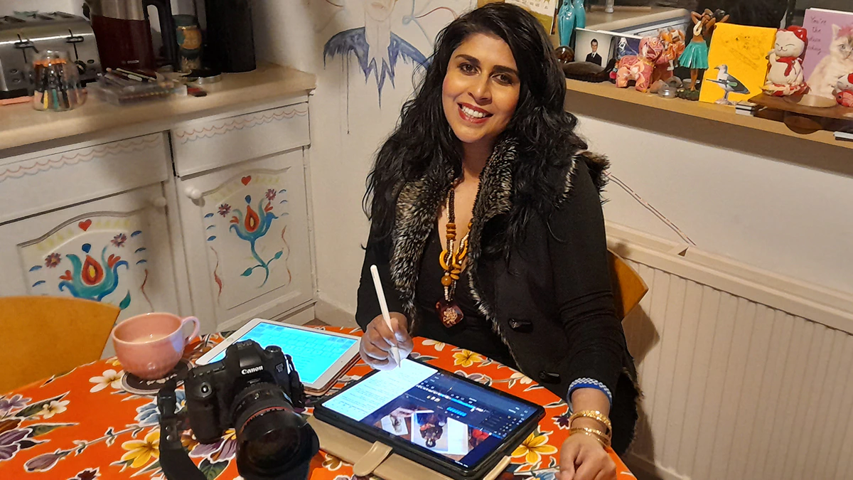 A woman sitting at a table and using a tablet
