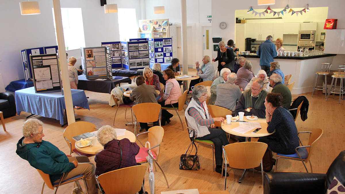 A range of people sitting in a cafe and talking