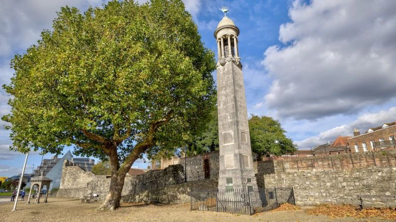 A tall memorial standing next to a tree