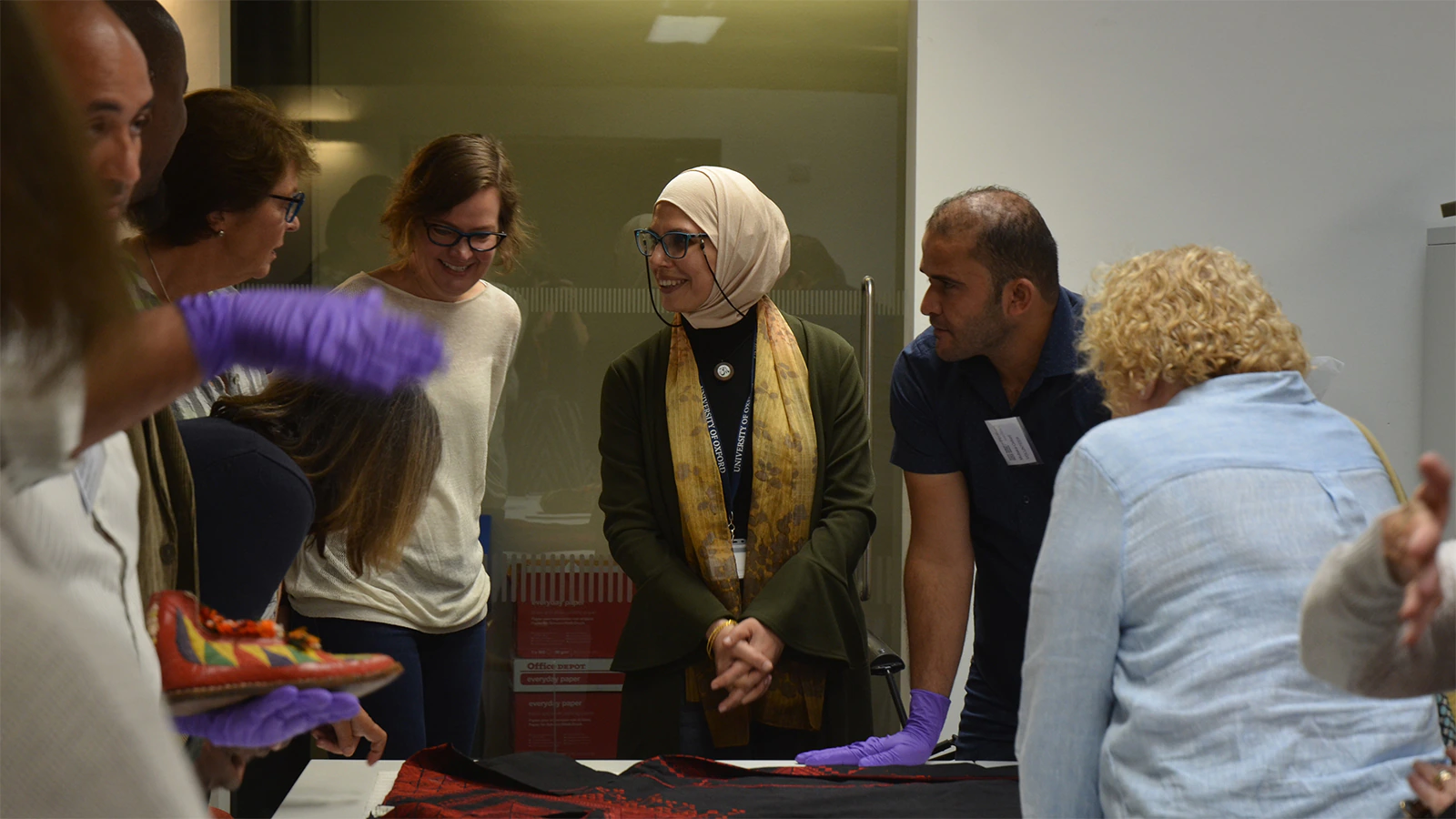 Members of the Multaka Project and visitors view textiles in the Pitt Rivers Museum research space