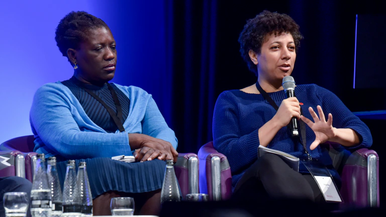 Two people speak on a conference panel