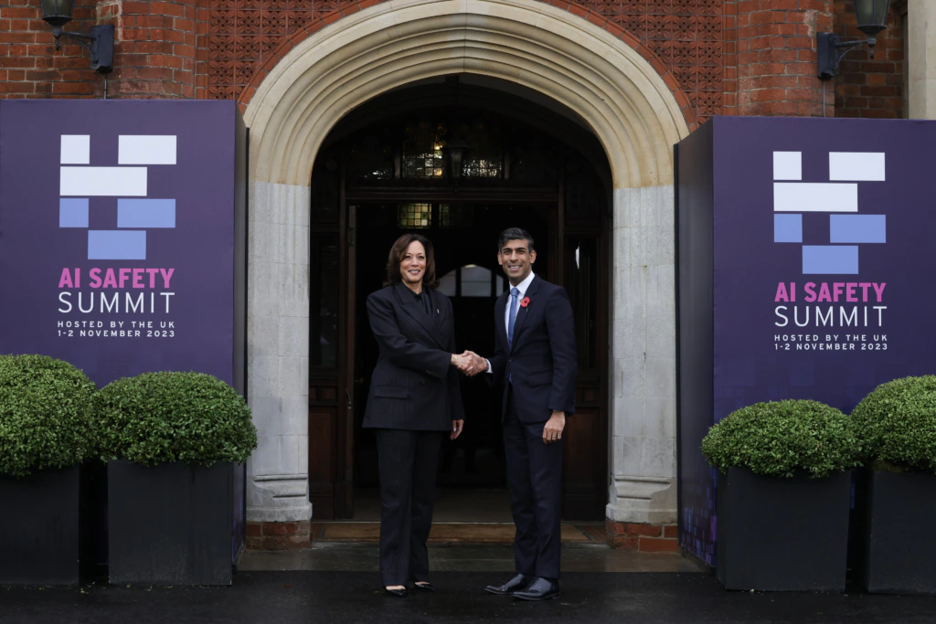 Rishi Sunak and Kamala Harris shaking hands on the entrance steps to Bletchley House