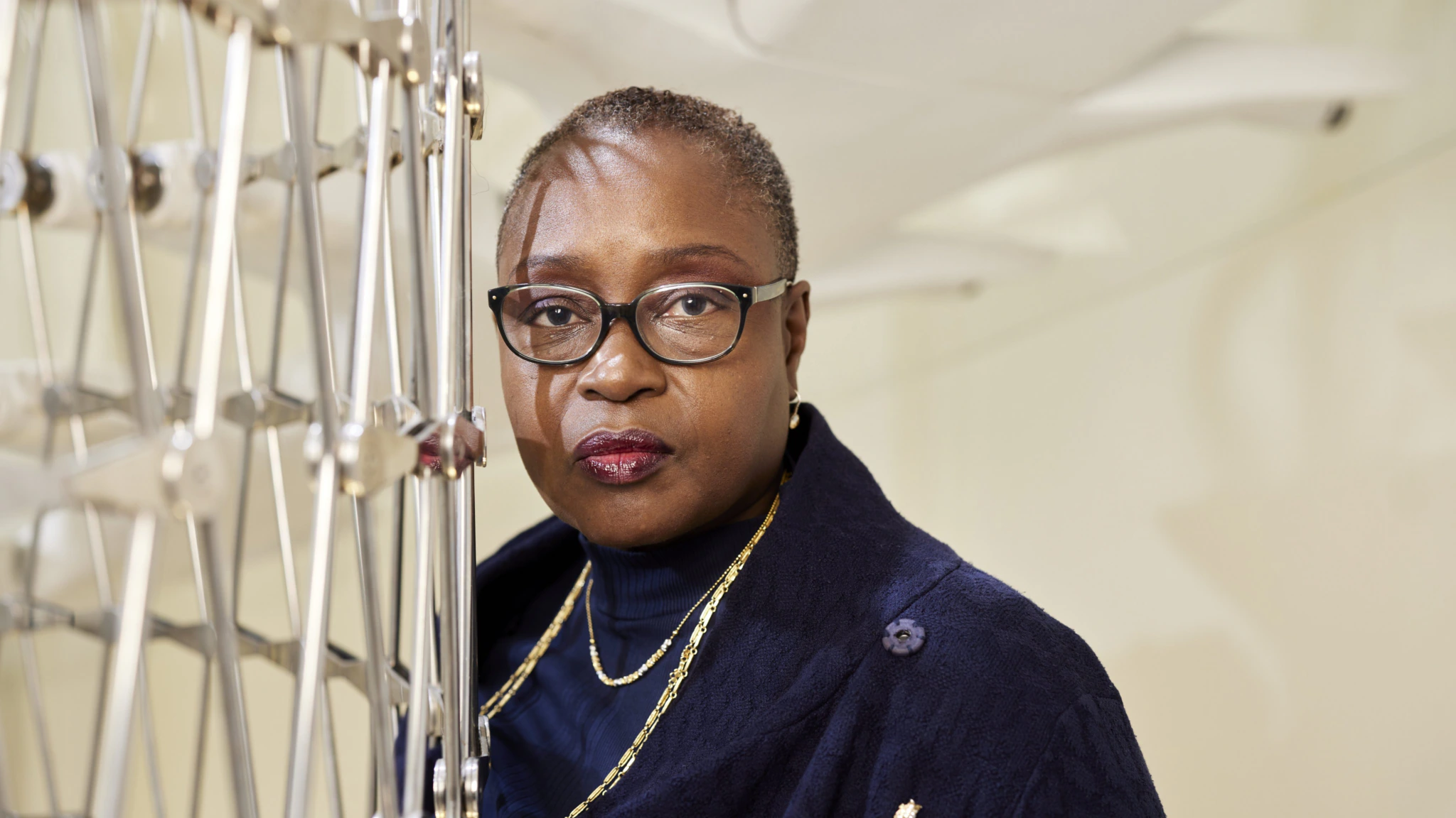 A close up of Hilary Carty, a Black woman in her fifties wearing a dark suit and gold jewellery