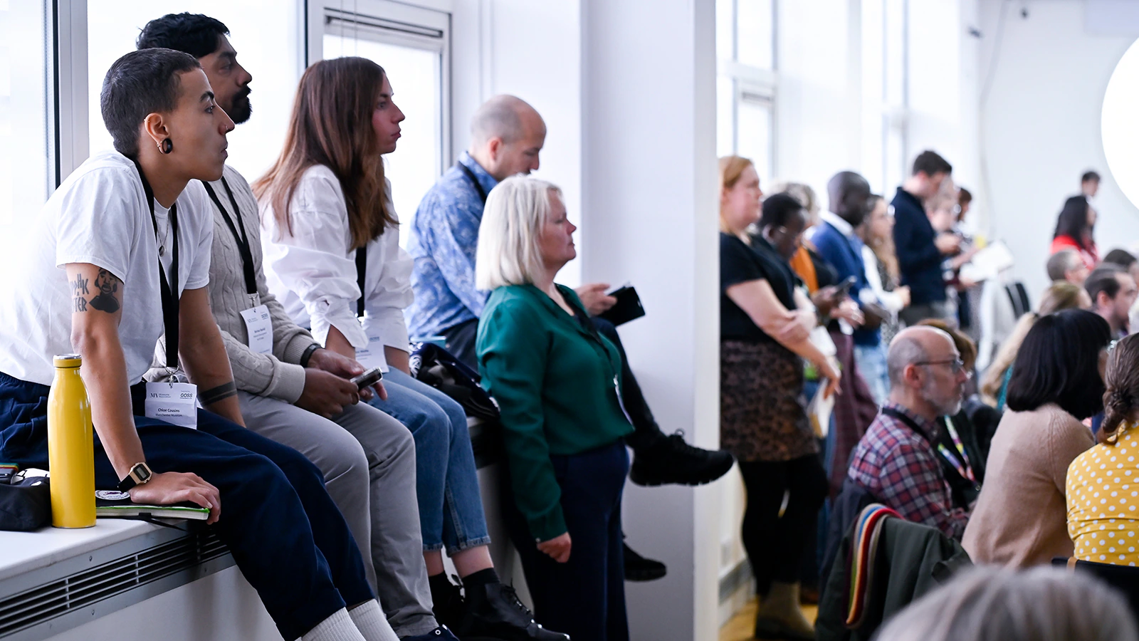 People sitting and standing in a room at a conference