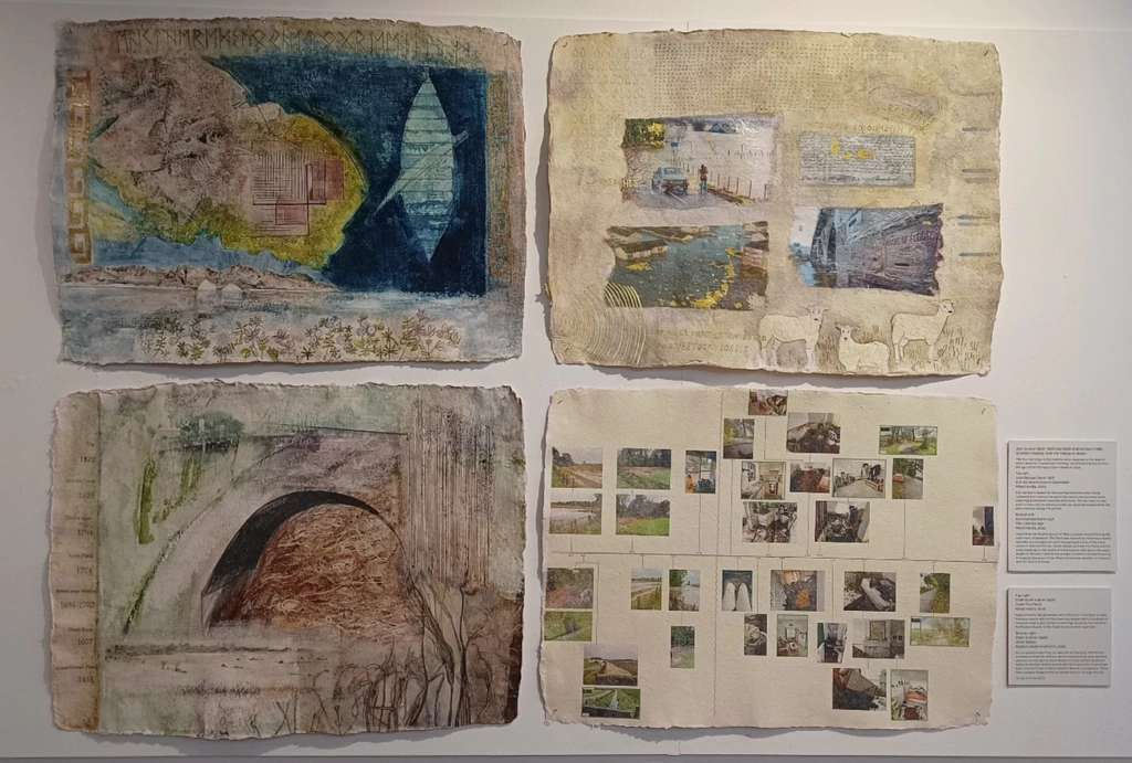 Four textured, mixed-media art pieces are mounted on a wall. Each piece contains layered images, sketches, and text, including nature scenes, bridges, figures, and photographs arranged in grid patterns