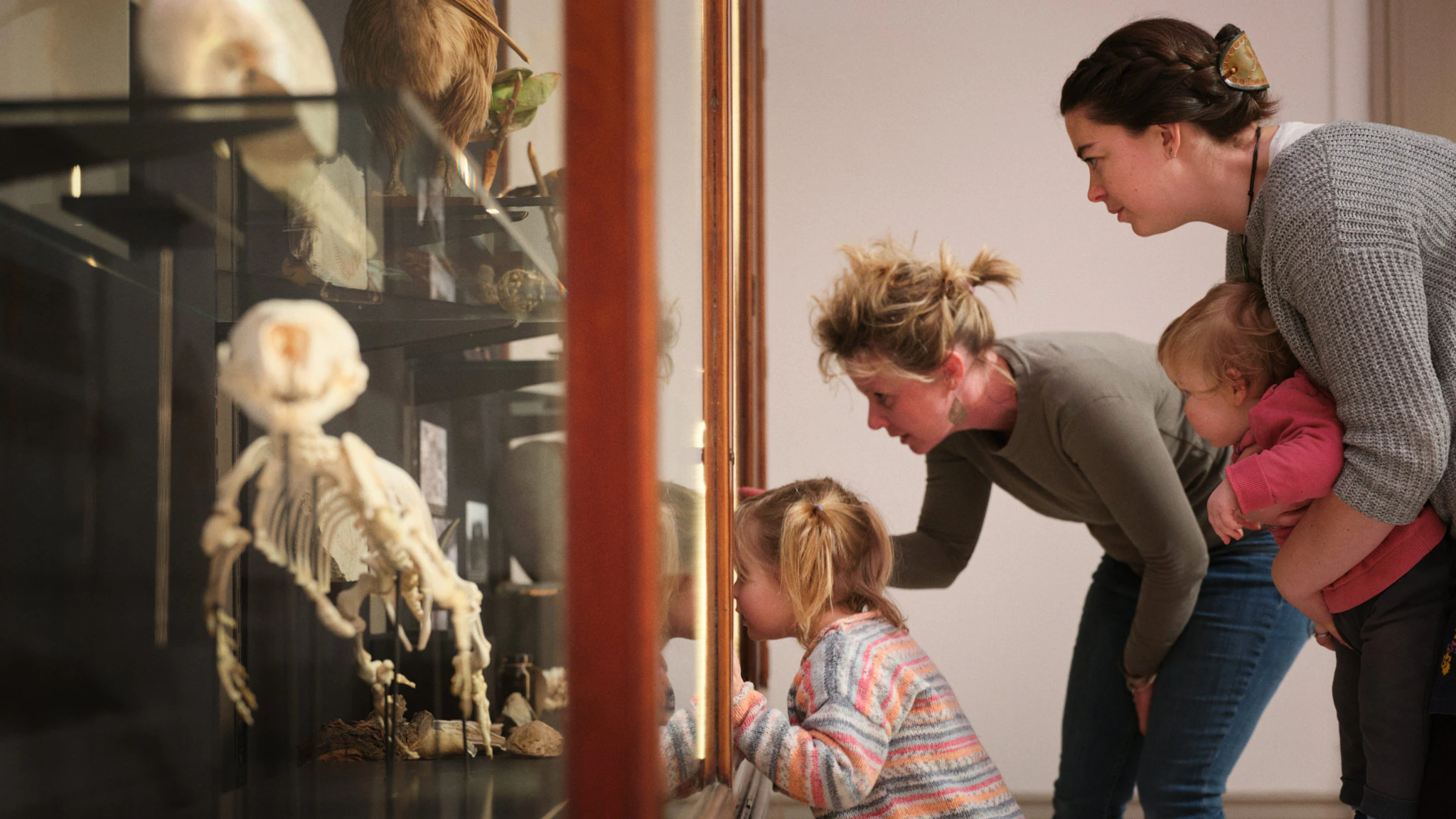 A family with two children look into a display case at a museum
