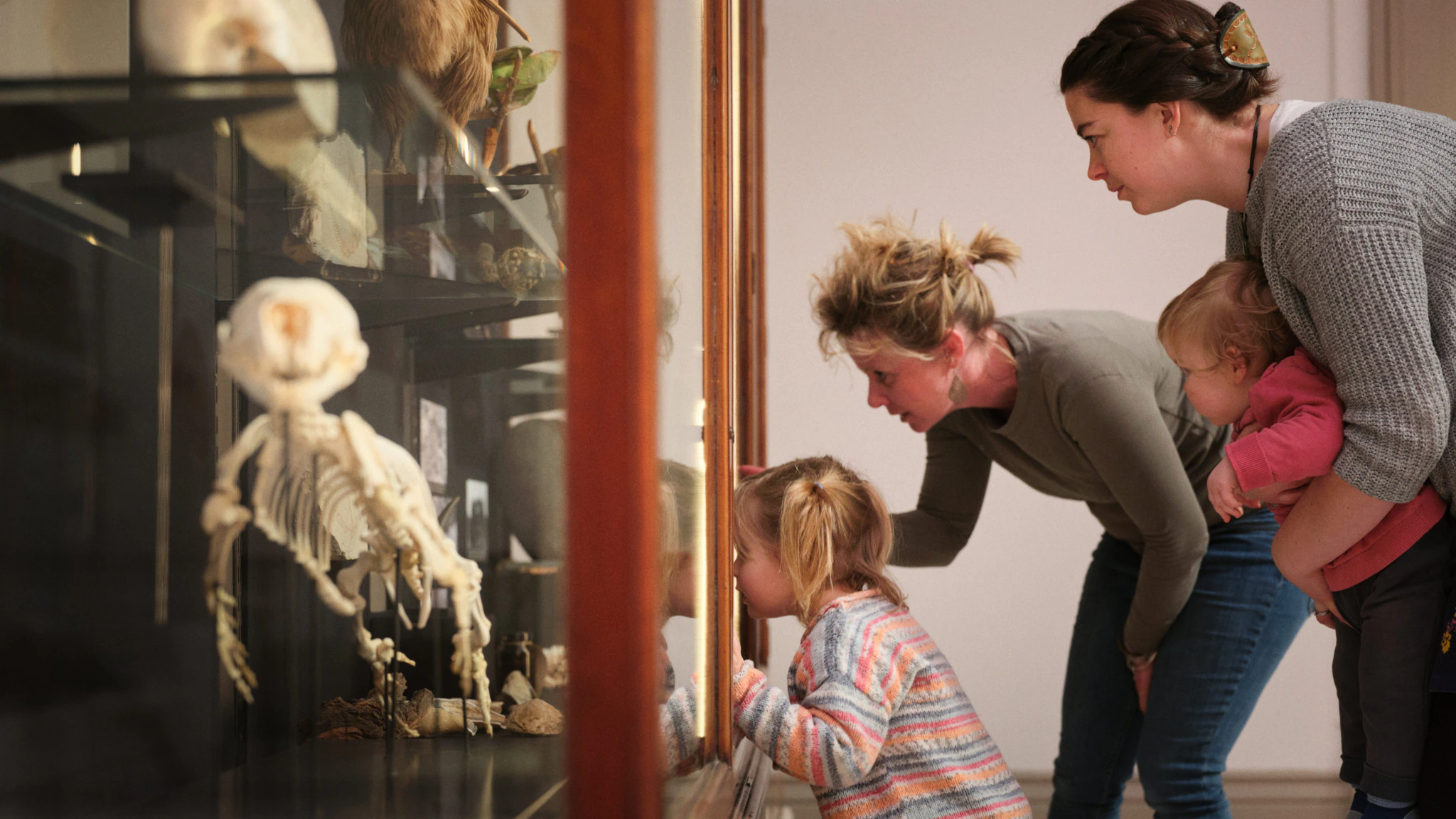 A family with two children look into a display case at a museum