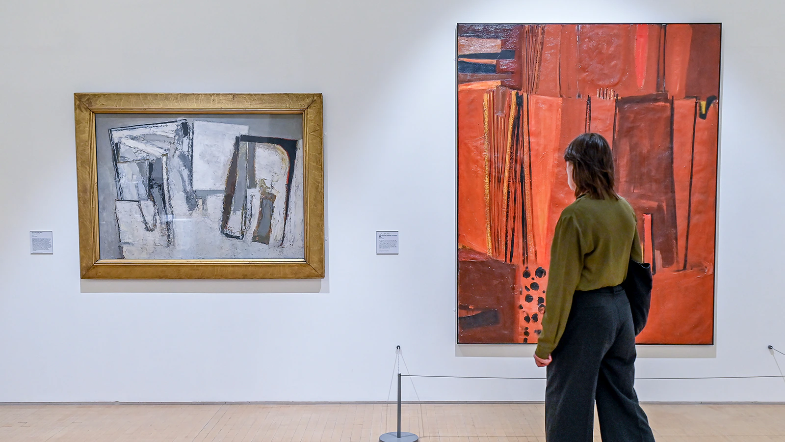 A person looks at artworks on the wall of a gallery