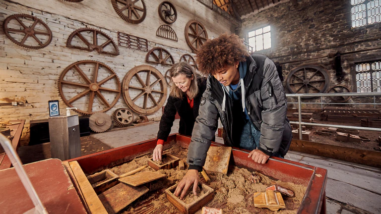 Visitors sifting through sand in the Foundry at Amgueddfa Lechi Cymru – National Slate Museum, which is currently undergoing redevelopment