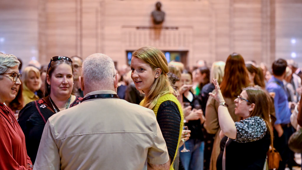 People gather in a large hall and discuss