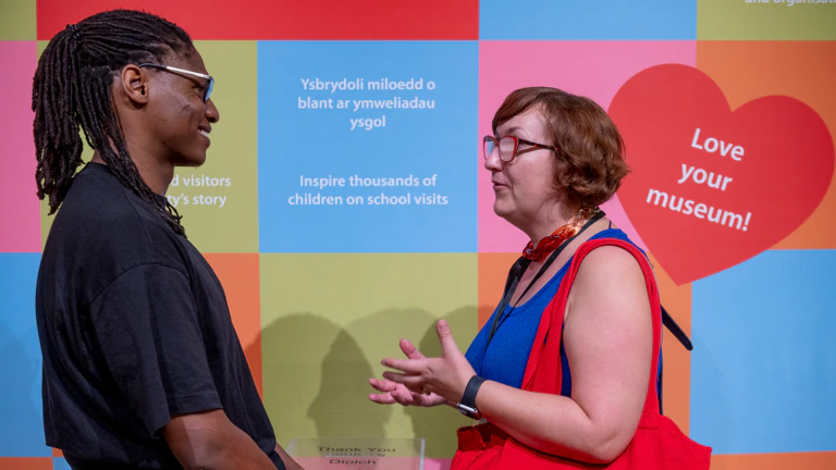 Two people stand and talk at the Museum of Cardiff