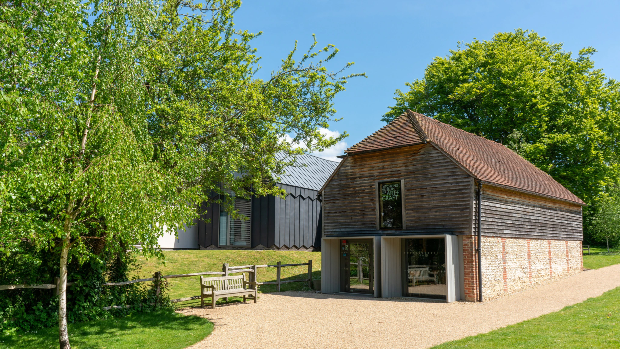 An exterior view of a historic farm building surrounded by greenery