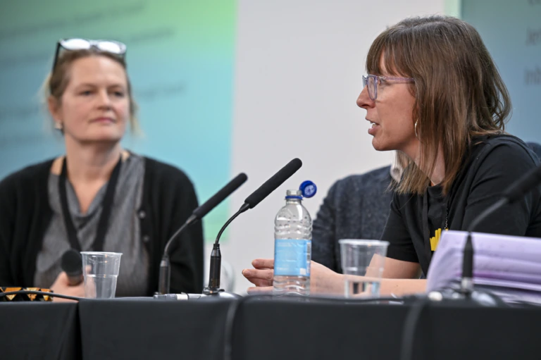 Two people speak on a conference panel