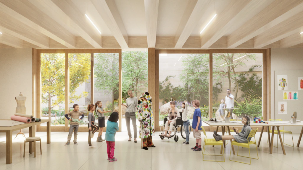 A bright, modern classroom with large windows showing trees outside. Children of diverse abilities interact, including a child using a wheelchair. Tables hold art supplies, and a mannequin stands at the center.