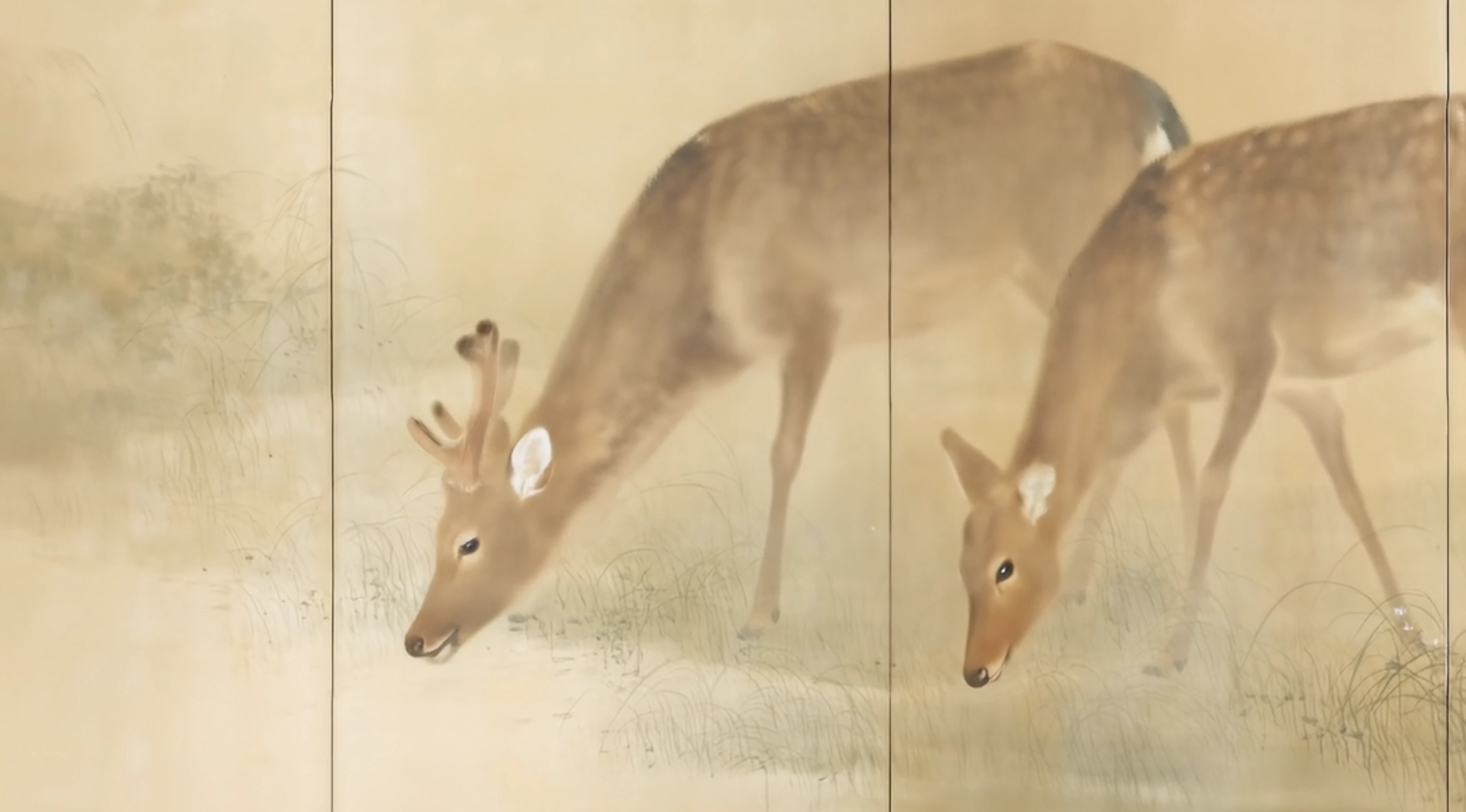 Two deer with brown fur and white spots gently graze on grass in a soft, muted landscape painted in traditional Japanese style, with a pale beige background and delicate brushwork.