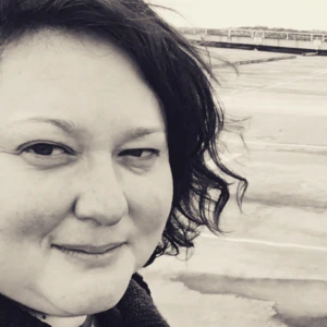 A woman takes a selfie on a rooftop. The image is in black and white.