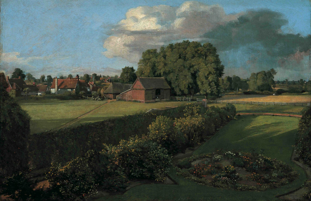 A sunny rural scene with green fields, gardens, hedges, and trees. Red-roofed houses and a barn stand near the center. Blue sky with clouds stretches above the landscape.