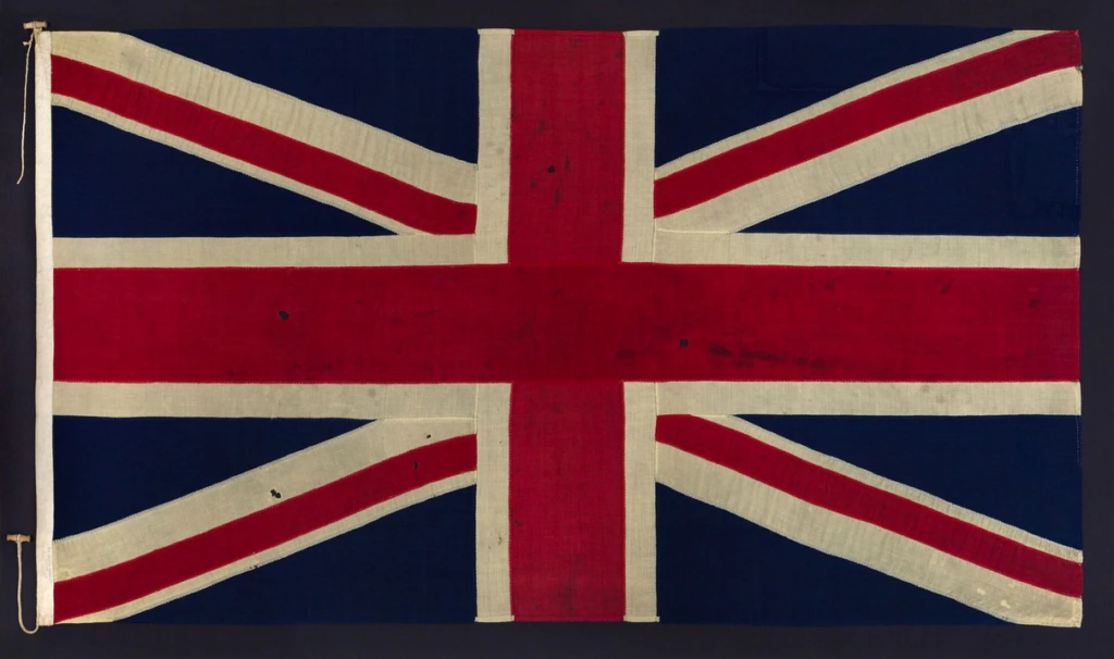 The image shows the Union Jack, the national flag of the United Kingdom, featuring red, white, and blue crosses and diagonals on a rectangular background.