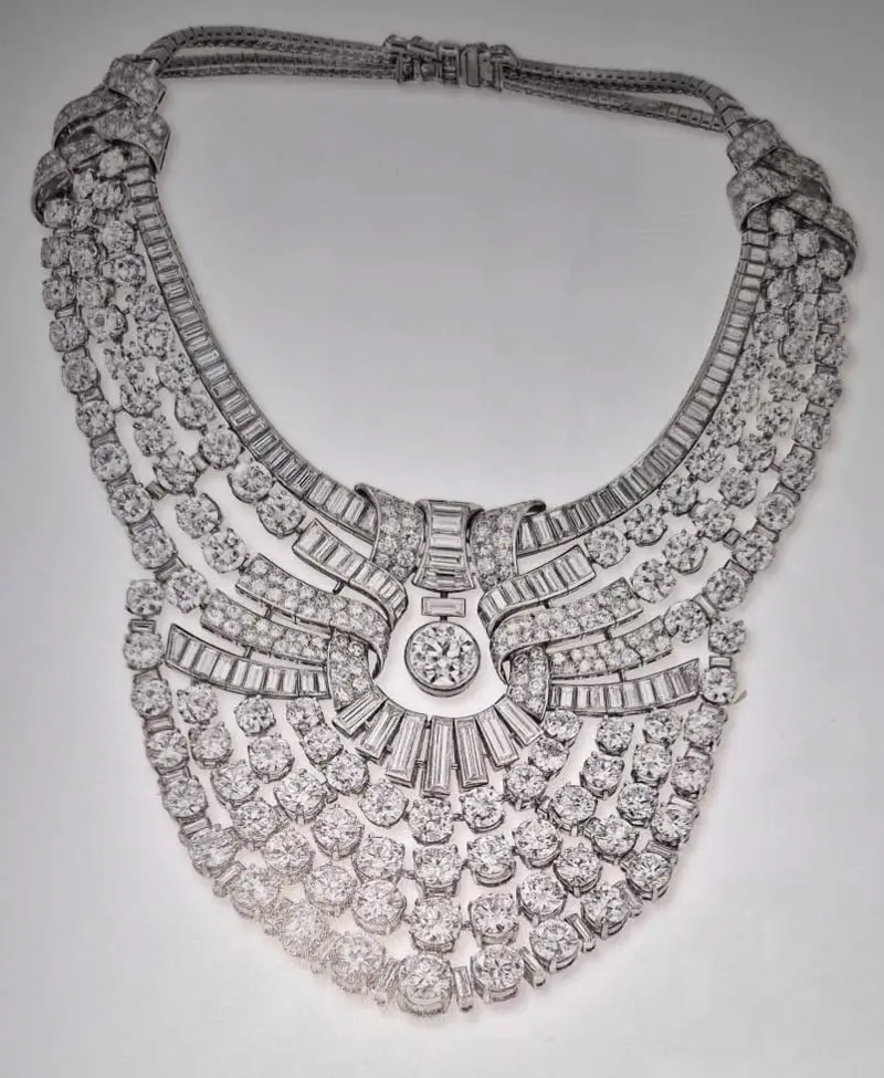 A luxurious, multi-layered diamond necklace featuring rows of sparkling round and baguette-cut diamonds arranged in an intricate, symmetrical design.