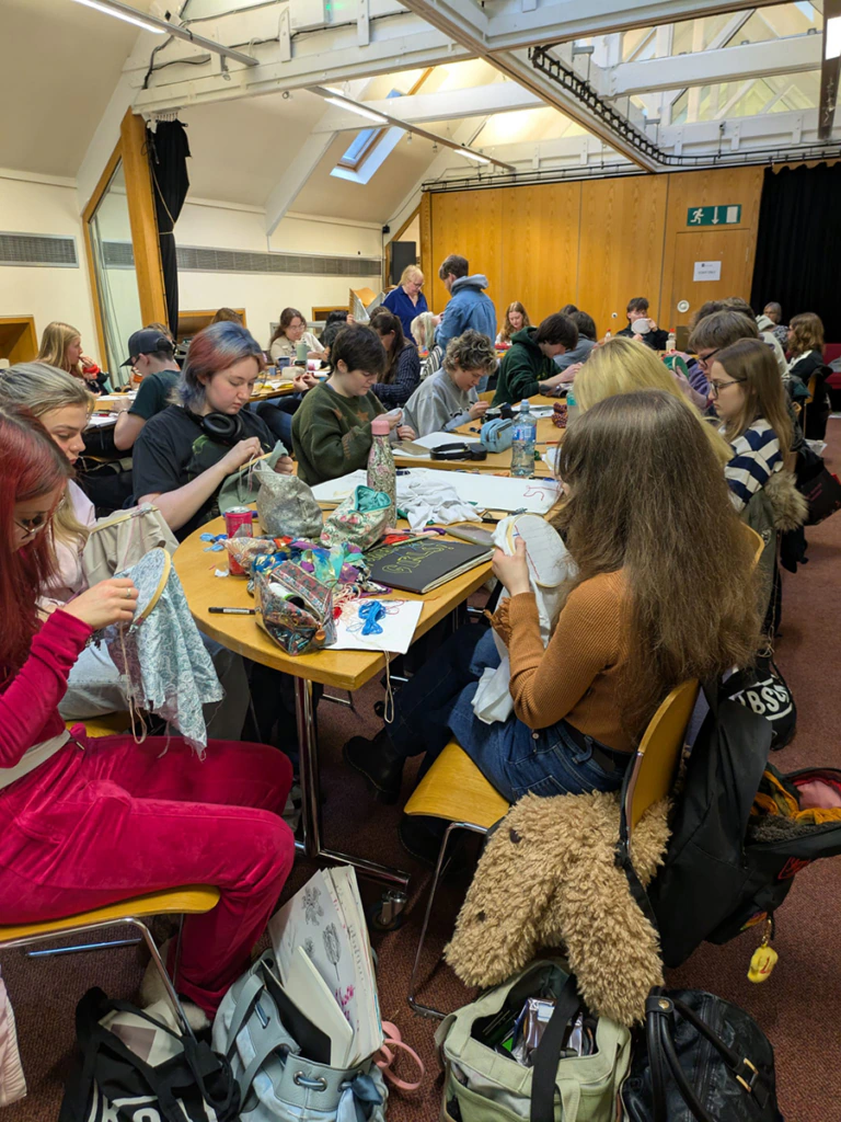 People sit around a table engaging in craft activities