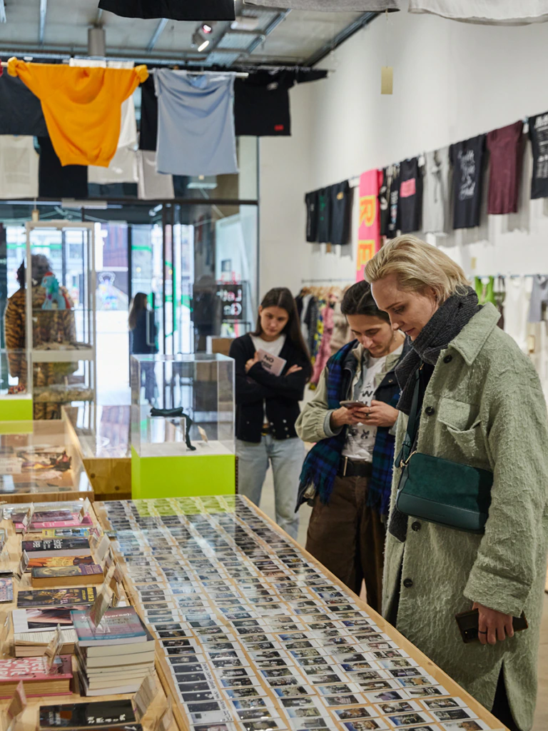 People looking at a display case of photographs at the Transcestry exhibition