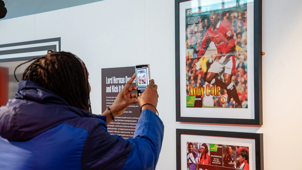 A person takes a photo with their phone while looking at a museum exhibit