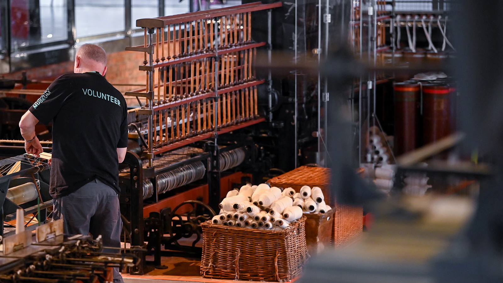 A volunteer works on a mechanical exhibition at a museum
