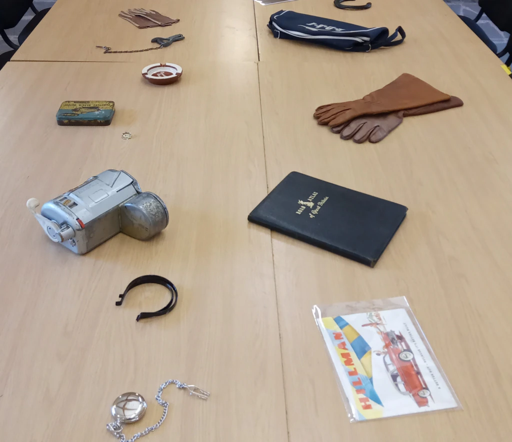 An assortment of memory objects assembled on a table, including some leather gloves