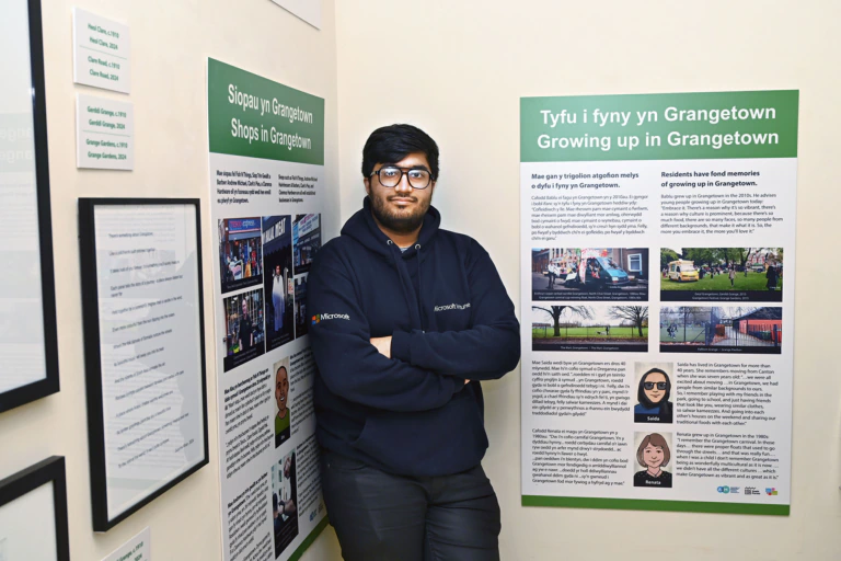 A young person stands with the Voices of Grangetown exhibition