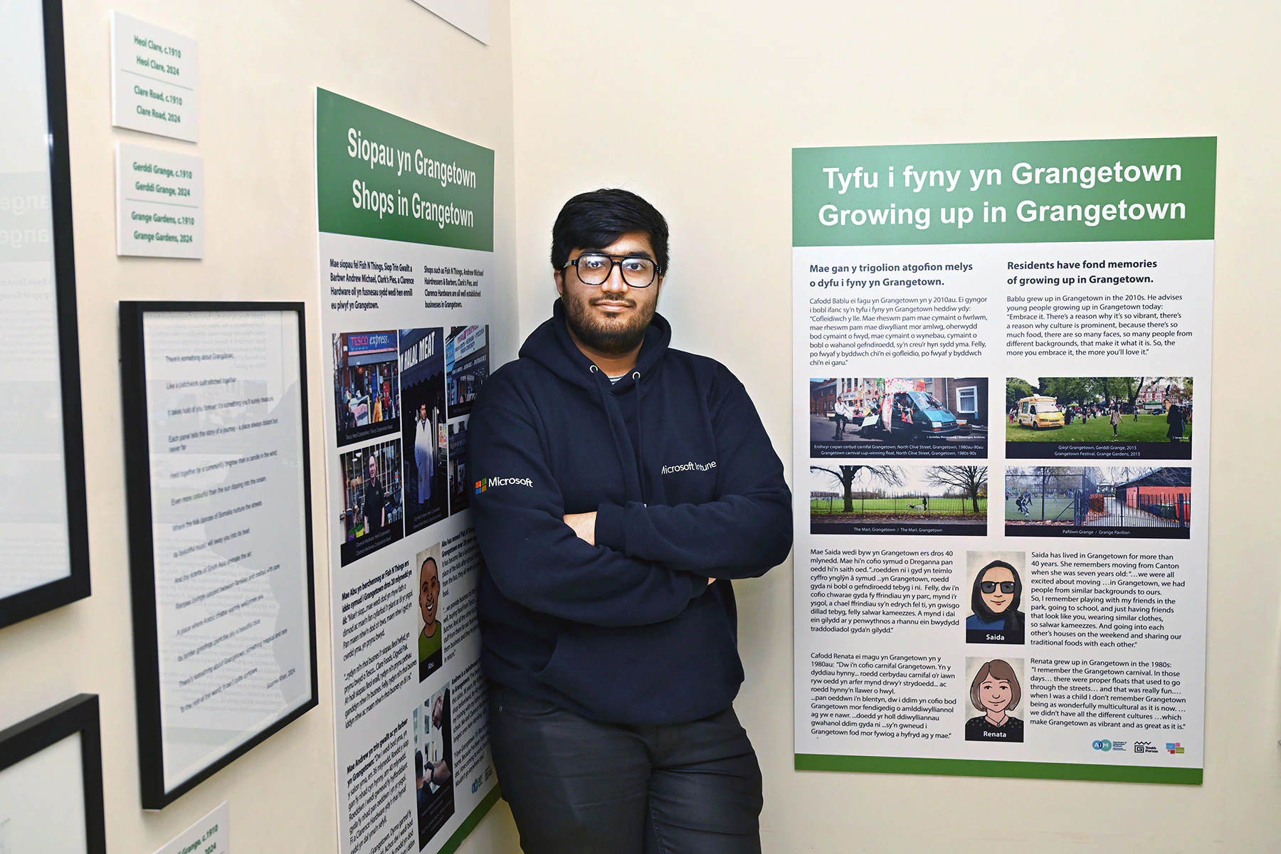 A young person stands with the Voices of Grangetown exhibition