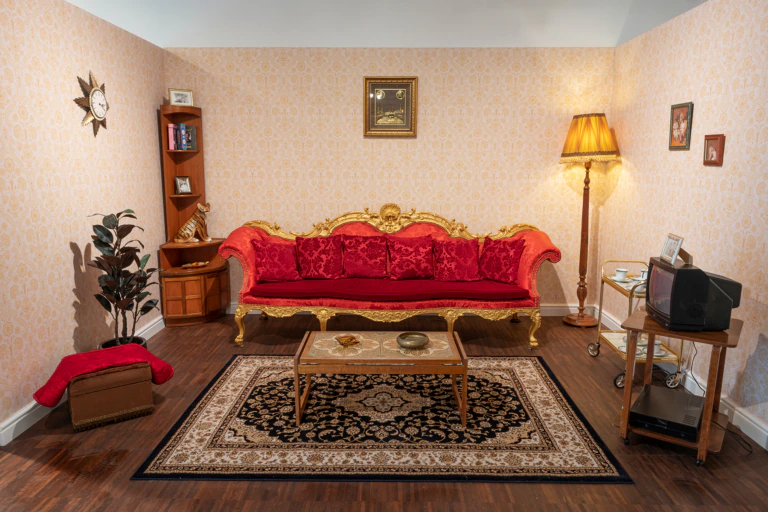 A red sofa showing a reimagined 1970s South Asian living room